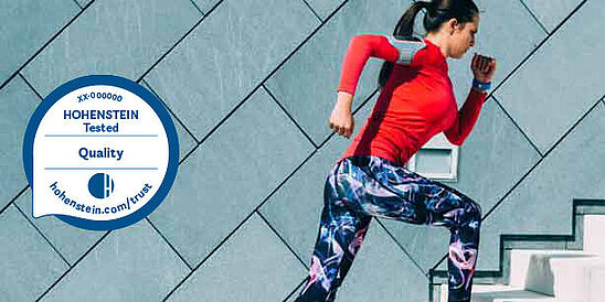 Performance Woman running in performance gear, plus the Hohenstein Quality Label