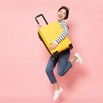 Hardlines Testing Woman holding yellow, hard-sided luggage