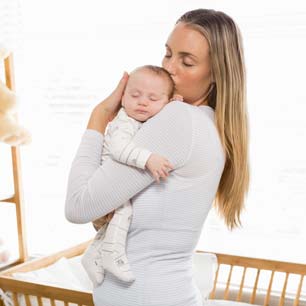 Biological Safety mom holding newborn near crib