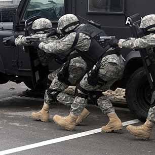 Ballistic Armor Comfort Military personnel wearing ballistic vests in a crouched position
